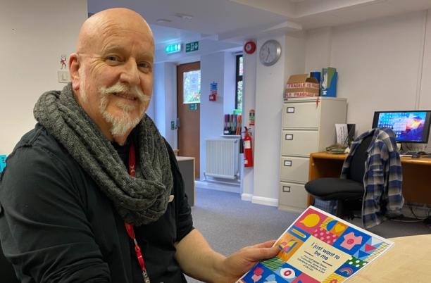 Michael, Education Facilitator at Cornwall Hospice Care, holding the Hospice UK report, 'I just want to be me'