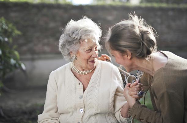 young woman looking at elderly woman