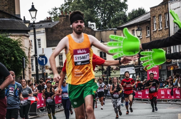 Man wearing orange vest running in a marathon