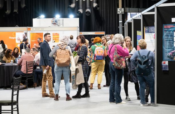 People looking at posters and exhibition stands at Hospice UK National Conference 2024