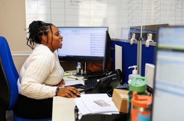 A woman smiling working at a computer