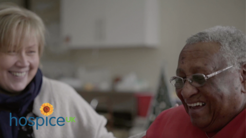 Two women laughing in a hospice setting
