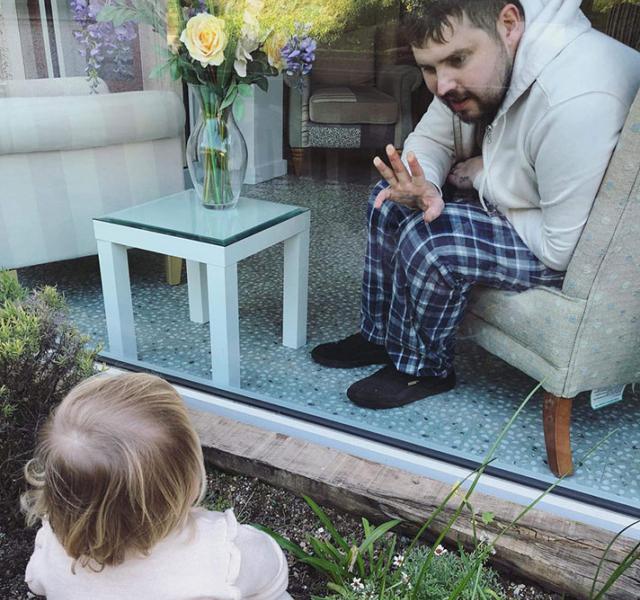 Tom, waving to his daughter Poppy at St Luke's Hospice in Plymouth