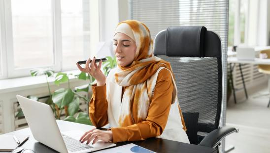 woman with hijab speaking on the phone at work